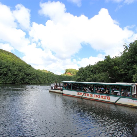 a boat traveling along a river next to a body of water