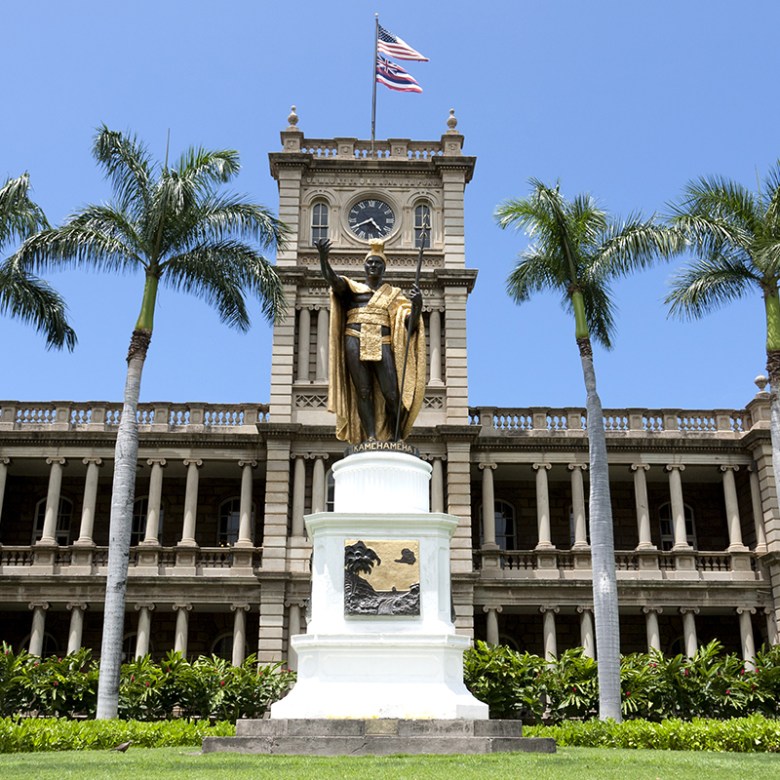a large clock tower in front of Iolani Palace