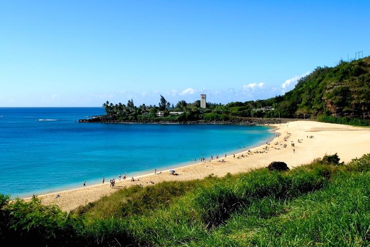 a sandy beach next to a body of water
